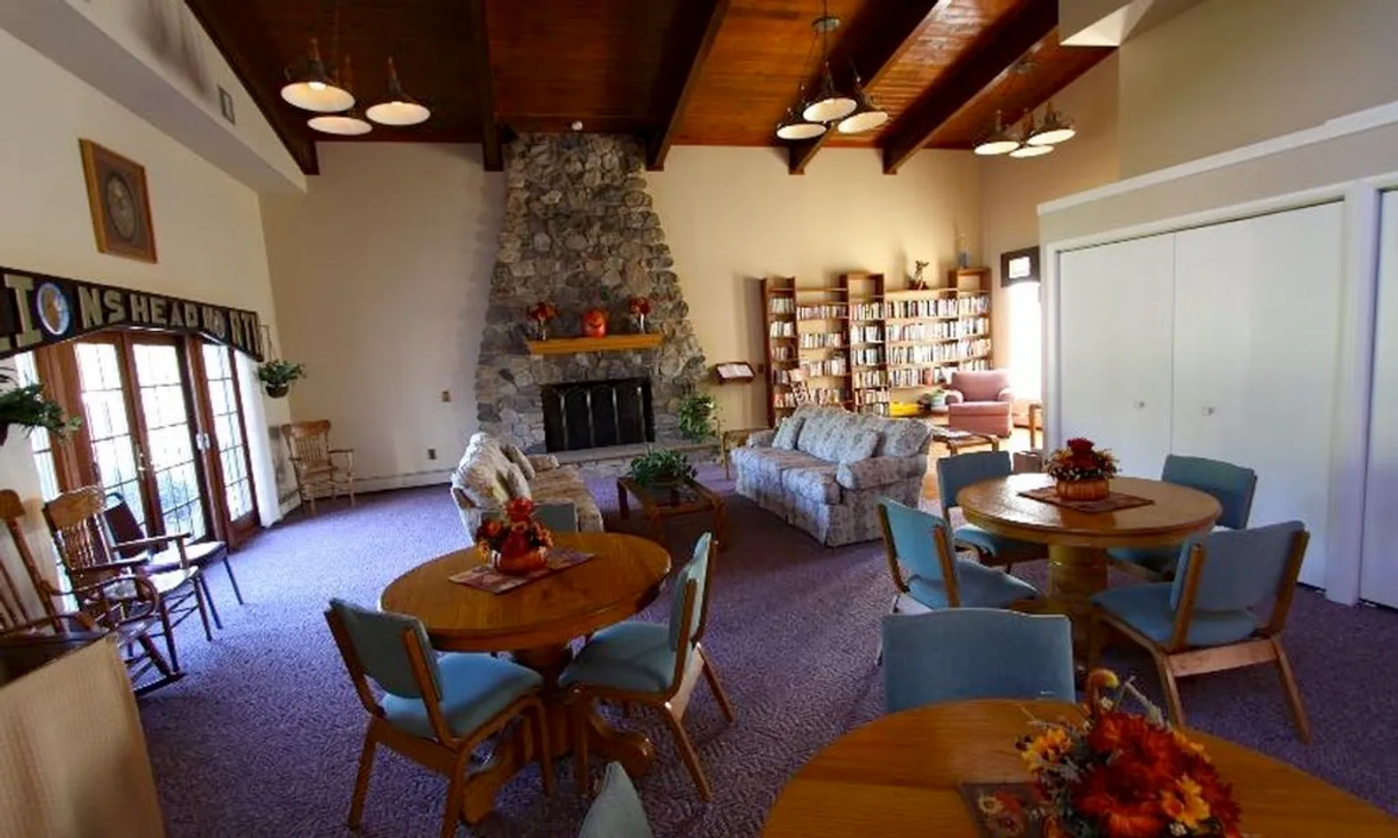 Clubhouse library with book shelves, reading chairs and puzzle tables